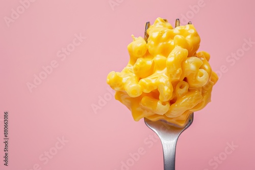 A close-up photograph of creamy mac and cheese, featuring a fork with a bite-sized portion of the cheesy pasta, against a soft pastel pink background