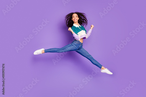 Full size photo of nice young girl jump raise fists wear shirt isolated on violet color background