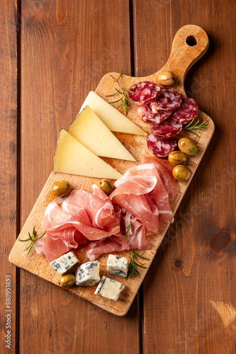 Tagliere con affettati misti: gorgonzola, prosciutto crudo, pecorino e salsiccia secca di maiale, gastronomia italiana, cibo europeo 