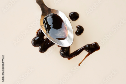 Balsamic vinegar from Modena on a spoon. An important ingredient in the sauce of Italian cuisine. Balsamic notes in perfumery, balsamic mood. Warm sunlight, eco simple style. Earth tones 