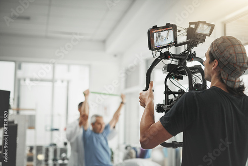 Man, videographer and recording with camera for online vlog, filmmaking or documentary at studio. Young male person or producer with physical therapist for behind the scenes, production or practice