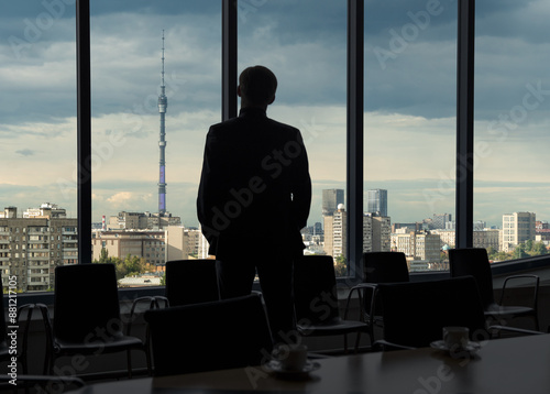 Man looking through office window on Moscow Ostankino TV tower in Russia. Panorama of the Russian city during sunset