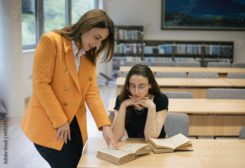 Professor supervising student in library