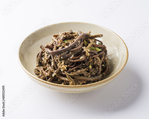 Close-up of Gosalinamul(Bracken Salad) with bracken and sesame on jar bowl and white floor, South Korea 