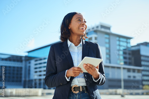 Confident Businesswoman Using Tablet in Urban Setting, Smiling and Looking Forward