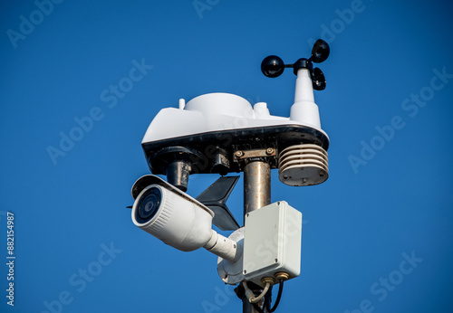 Modern Surveillance Technology: Security Camera, Weather Station and Sensors Against Clear Blue Sky