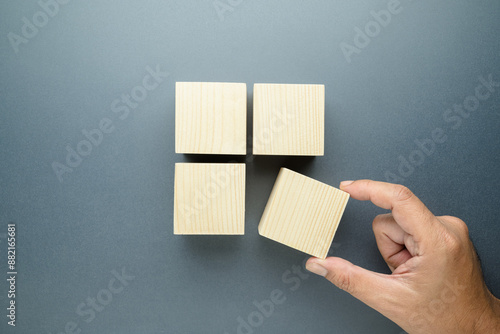 Closeup hand of a man pulling a piece of wood cube out of the group, a quarter needed concept, system implementation, market share or narrow target, and niche