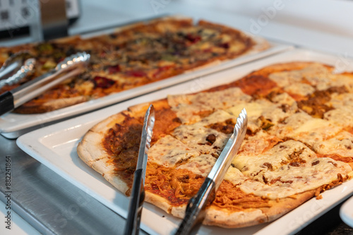 Bandeja con pizzas cortadas para un almuerzo en un bufet de un restaurante. 