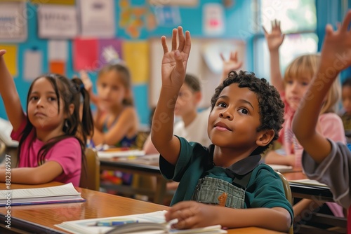 Portrait of black schoolboy raising hand in classroom during lesson at elementary school 