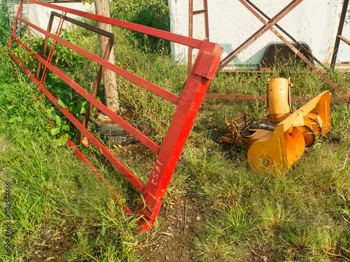 Metal Red Fence With A Yellow Auger On The Ground