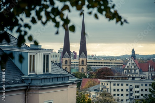 Ausblick über die Stadt Bielefeld bei bedecktem Himmel auf Wohnhäuser, das Landgericht und die beiden Türme einer Kirche.