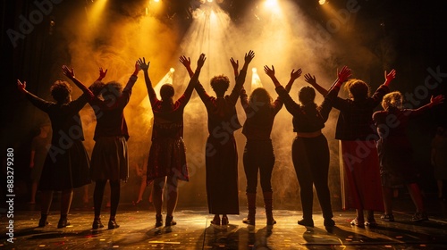 A group of diverse actors take a bow on stage after a successful performance, bathed in the warm glow of the spotlight against a dark background.