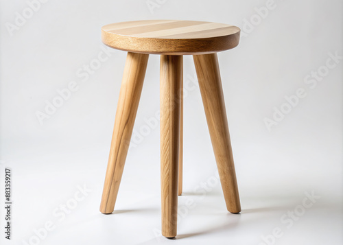 Simple yet elegant three-legged wooden stool with clean lines and minimal ornamentation, crafted from solid wood, exuding warmth and functionality in a modern space.