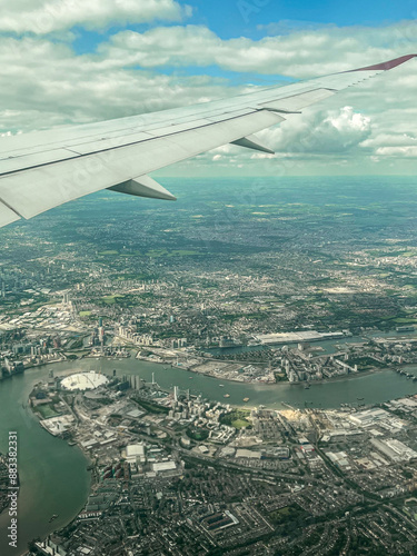 Aerial view of London. View of the city centre of London from the window of the plane. Flying over the city with blue and grey landscapes. View of the river and skyscrapers.