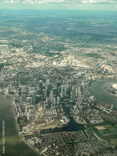 Aerial view of London. View of the city centre of London from the window of the plane. Flying over the city with blue and grey landscapes. View of the river and skyscrapers.