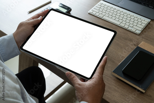 A businessman holds a mockup. iPad digital tablet with blank screen Mockup replaces your design mockup in the office.