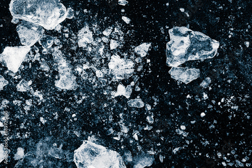 Ice, crushed on a black background. Pieces of crushed ice spread away. Crushing of the ice.