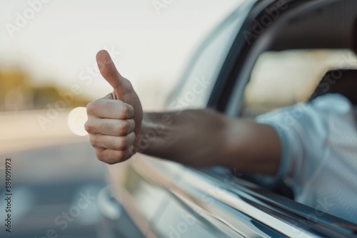 Thumbs up gesture from a car window on a sunny day. Positive feedback and approval concept.