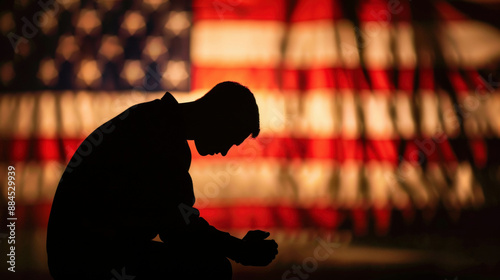 Silhouette of man kneeling in prayer with American flag background. Faith, devotion and patriotism