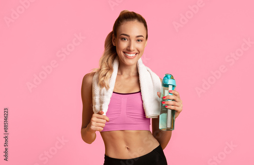 Hydration. Fitness Girl Holding Water Bottle And Towel Posing On Yellow Studio Background. Empty Space