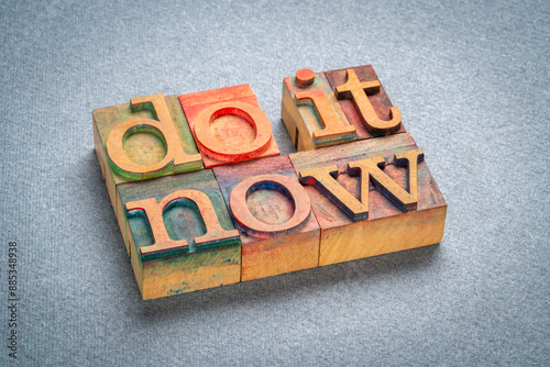 do it now - motivational text in retro letterpress wood type stained by color inks, productivity concept