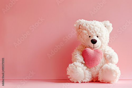 a white teddy bear holding a heart