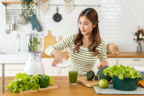 Portrait of beauty healthy asian woman making green vegetables detox cleanse and green fruit smoothie with blender.young girl drinking glass of smoothie, fiber, chlorophyll in kitchen.Diet, healthy