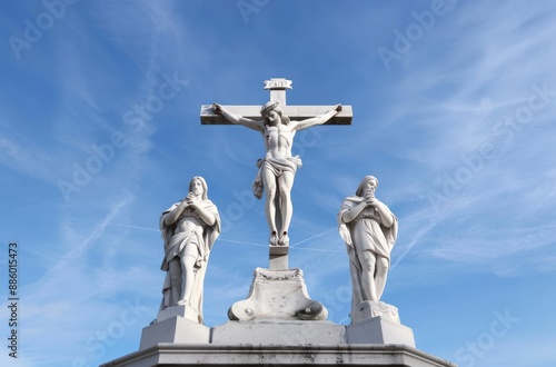 Statues of Jesus Christ on the cross with two other figures against a blue sky backdrop, representing a religious scene.