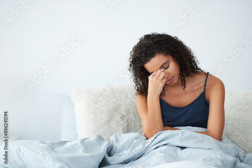 Woman, waking up and stress in bedroom with headache, fear or frustrated for insomnia or mental fatigue. African person massage head for pain, anemia or tired in morning with iron deficiency at home