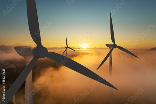 Wind turbine silhouette at sunrise, wind energy and nature concept.