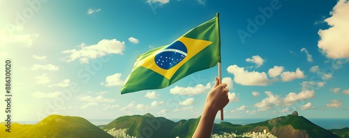 Hand holding Brazil national flag on blue sky. Happy Independence Day, Labor Day, Proclamation of the Republic. Background with copy space for greeting card, banner, poster