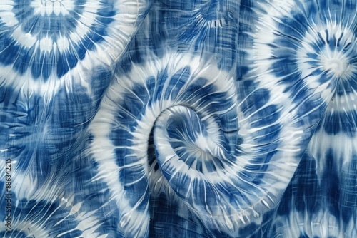 A photograph of fabric displaying a Shibori pattern with spiral tie-dye designs in deep indigo and white