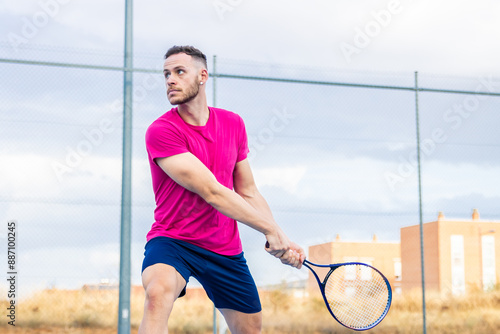 Young man executing backhand on tennis court