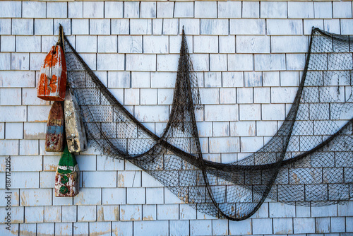 fishing net and weathered floats hanging on a wooden shingled wall room for text shot peggy's cove nova scotia