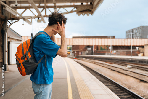 Man Covering Ears While Waiting on Train Platform