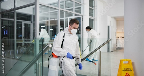 Man, cleaner and fumigation for hygiene, fresh and disinfectant for virus protection and maintenance. People, ppe suit and spray for bacteria, disease and prevention in office as team in pest control