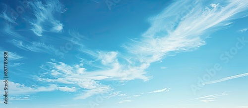 A serene scene of clear blue skies with wispy white clouds peacefully drifting in the airy atmosphere creating a tranquil copy space image