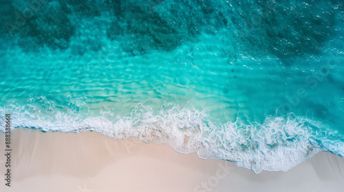 Aerial view of a beautiful sandy beach by the ocean with crystal clear turquoise water