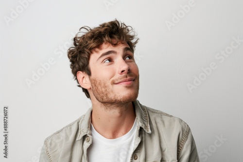 Portrait of a happy European man dressed casually looking satisfied and smiling noticing something in the distance