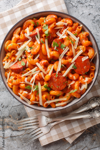 Gochujang Pasta combines al dente macaroni with a bold and fiery gochujang sauce closeup on the plate on the table. Vertical top view from above