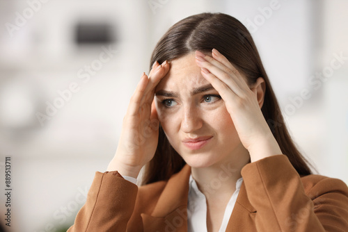 Portrait of embarrassed young woman in office