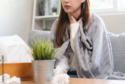 Seasonal sick in winter. Young Asian woman touching her neck feeling hurt in the throat have inflammation and cold.