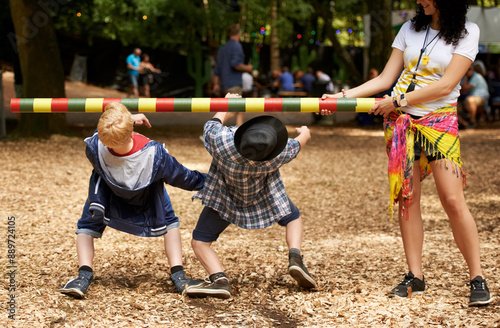 How low can you go. Shot of two kids doing the limbo at an outdoor festival.