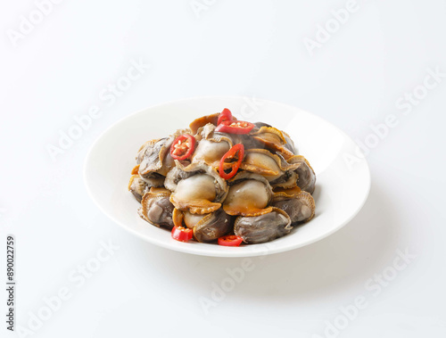 Close up of blanched ark shell flesh with red pepper on dish and white floor, South Korea 