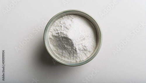 White zinc oxide powder in bowl on white table. Chemistry and medicine concept. Flat lay