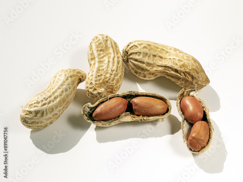 Close up of five peanuts with bean pods and brown seeds on white floor, South Korea 