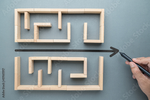 Hand draw a shorten straight line to go through the complication of a maze game, built by wood blocks, shorten process, simplify, and communication concept