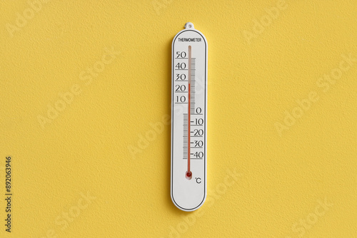 Home thermometer on yellow wall