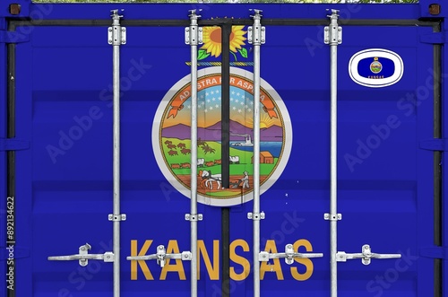 Kansas US state flag depicted on metal doors of shipping cargo container outdoors in docks area close up