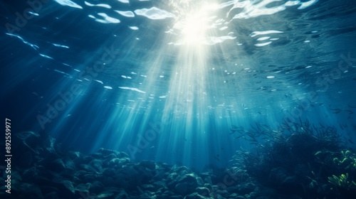 Ocean surface seen from underwater, deep blue tones and sun rays